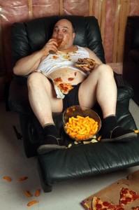 Hamburger fressender fauler Couch Potato auf Sessel Trainingsecke
