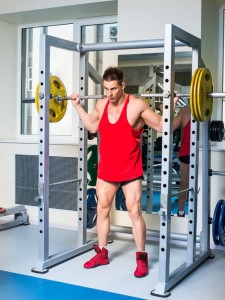 Mann Macht Kniebeugen mit Schwerem Gewicht mit Sicherung