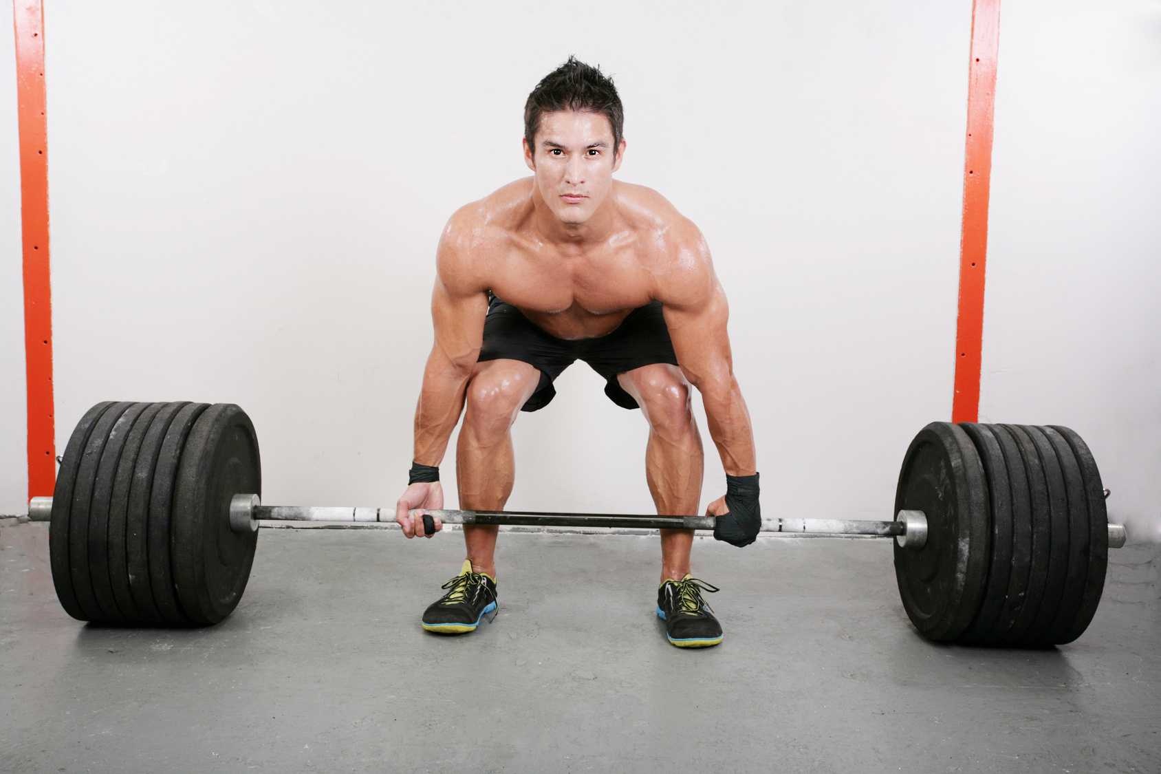 Muskulöser Mann macht eine der Grundübungen mit 200 kg (Kreuzheben)